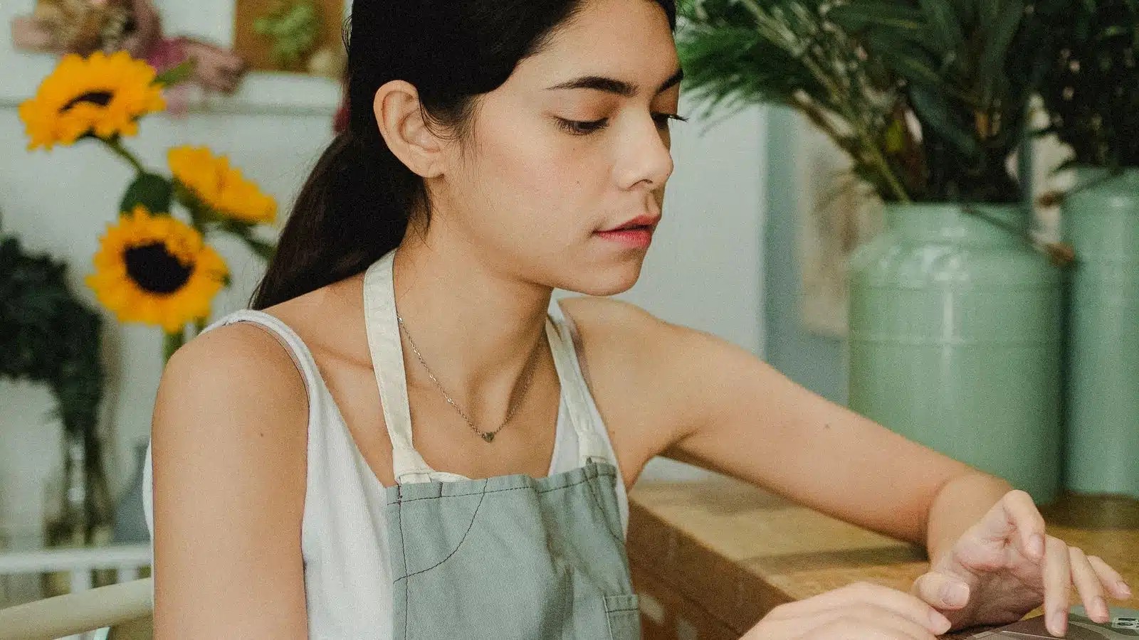 Independent florist reviewing her website maintenance cost and recent site updates on a laptop in her shop