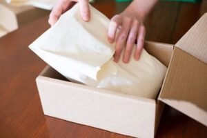 Small Business Websites 45 Online shop owner packing an order into a cardboard box